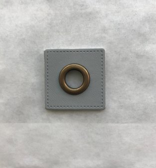 oud-koperkleurige nestels op een lichtgrijs vierkant van nepleer: gat diameter 8 mm
